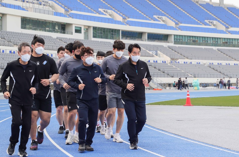 1-3. 백군기 용인시장이 조효상 용인시체육회장, 용인시청 씨름단 선수 등과 함께 용인마라톤 대회의 성공 개최를 위해 용인미르스타디움 주경기장 육상트랙을 달리고 있다..JPG