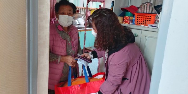 7. 유림동 지역사회보장협의체 위원이 한 어르신 댁을 방문해 세탁을 마친 이불을 돌려드리고 있다..jpeg