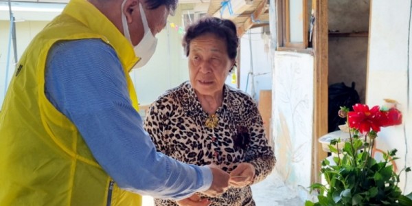 [크기변환]8. 모현읍 지역사회 보장협의체위원이 생일을 맞은 어르신께 꽃화분과 상품권을 전달하는모습.jpg