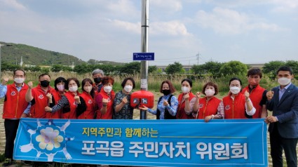 [크기변환]6. 포곡읍 주민자치위원회 관계자들이 경안천 산책로에 반려동물 배변봉투함을 설치한 후 기념촬영을 하고 있다..jpg