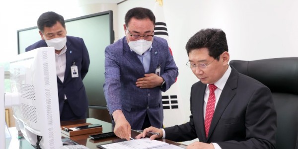 이상일 용인특례시장이 1일 수해 현장을 점검 한 뒤 글로벌 반도체 중심도시 추진전략을 첫 번째로 결재하고 있다. (1) (1).JPG