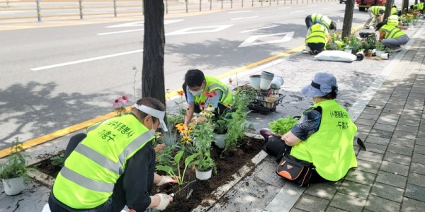 5-1. 신갈동 통장협의회와 노인회 등 주민 30여명이 가로수 주변에 꽃을 심고 있다..jpg