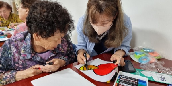 5-1. 한 어르신이 감각을 자극하는 미술 프로그램에 참가하고 있는 모습.jpg