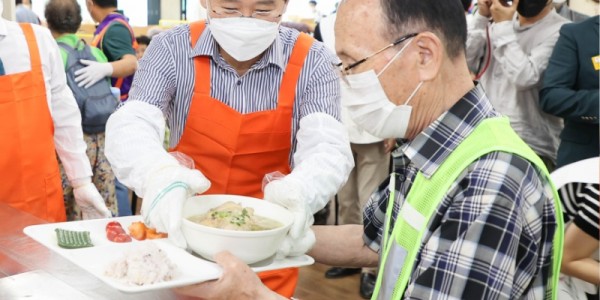 이상일 용인시장이 중복 맞이 삼계탕 나눔 행사에 참석해 한 어르신에게 삼계탕을 드리고 있다..jpg