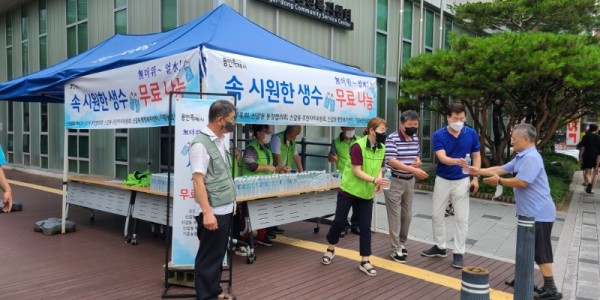 3. 신갈동 주민단체 위원들이 주민에게 생수를 나눠주고 있다.jpeg