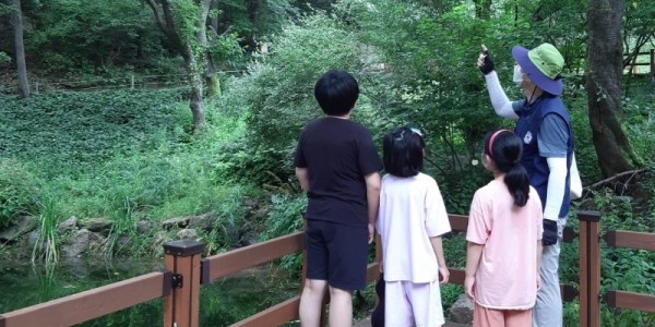 2-1. 용인자연휴양림 숲해설프로그램 참가자들이 야생화단지 산책로에서 설명을 듣고 있다..jpg