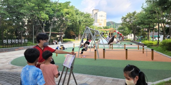 1. 마평어린이공원을 이용한 시민과 어린이들이 이용자 만족도 조사 패널에 스티커를 붙이고 있는 모습.jpg