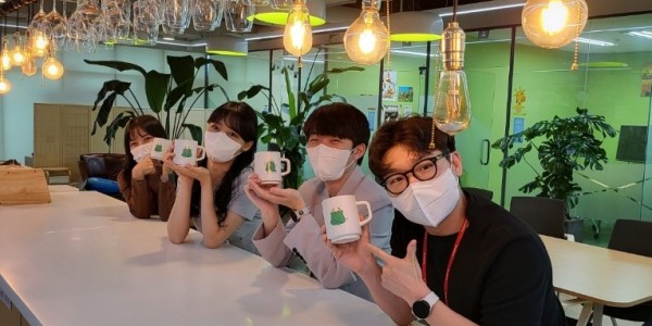 3. ㈜하이로닉 직원들이 조아용이 그려진 머그컵을 들고 환하게 웃고 있다..jpeg