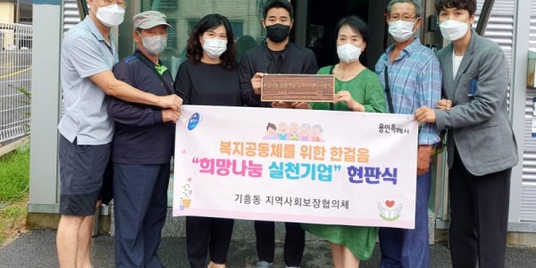 7. 기흥동 협의체 관계자들이 지엔티엔지에 희망나눔 실천기업 현판을 전달했다.jpg