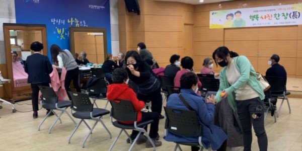 3. 유림동 지역사회보장협의체 위원들이 장수 사진 촬영을 위해 어르신들을 꽃단장시켜 드리고 있다.2.JPG