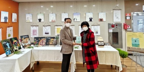6. 도서관 관계자가 박인선 반딧불이 대표와 _나도 시인_ 전시회장에서 기념촬영을 하고 있다2.jpg