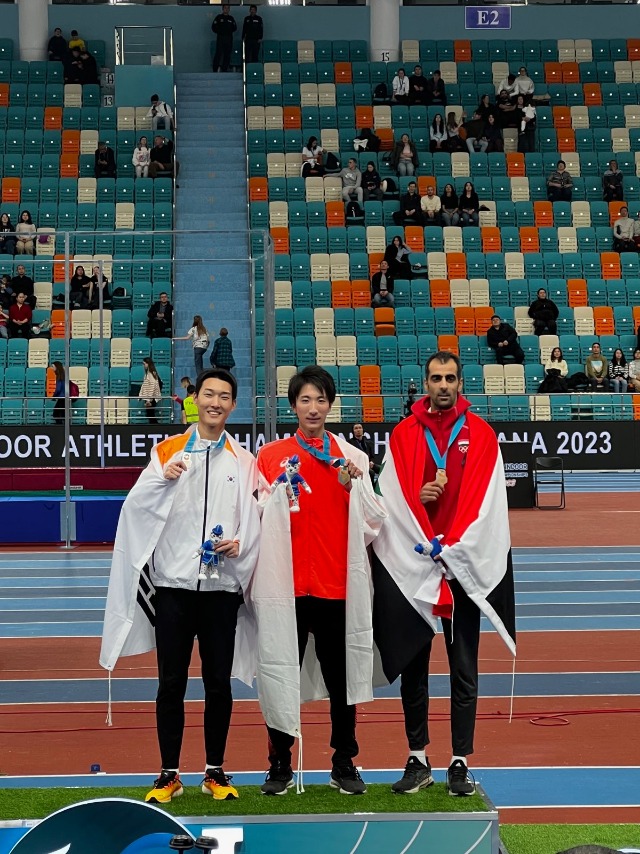 우상혁 선수가 1위, 3위 선수와 기념촬영을 하고 있다..jpg