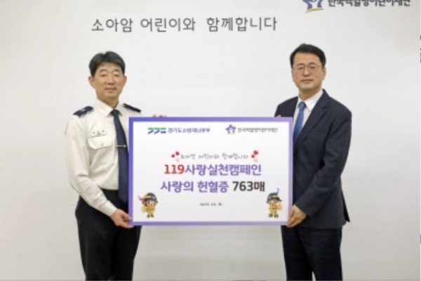 권용성 경기도소방재난본부 소방행정과장(사진 왼쪽) 이 서선원 한국백혈병어린이재단 사무총장에게 헌혈증서를 기부한뒤 기념촬영을 하고 있다.jpg