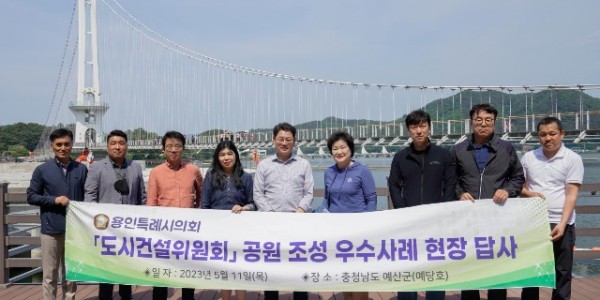 용인특례시의회 도시건설위원회 위원들과 시 관계자들이 기념 촬영을 하고 있다..jpg