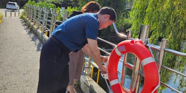 8. 마북동 관계자가 구성파출소 관계자와 함께 탄천 보도교 한 곳에 구명부환을 설치하고 있다..jpg