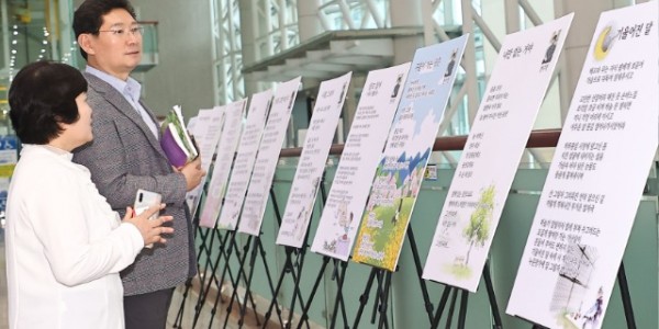 6. 이상일 용인특례시장(오른쪽)이 지난 14일 위영금 행복여정문학 대표(왼쪽)와 용인시청 로비에서 열리고 있는 시화전을 둘러보고 있다..jpg