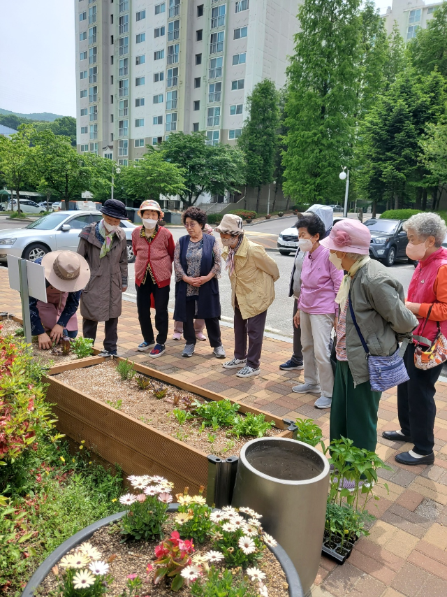 4-2. 용인특례시의 공동주택 텃밭지원사업에 참여한 초당마을 3단지 입주민들이 작물재배 교육을 듣고 있다.png