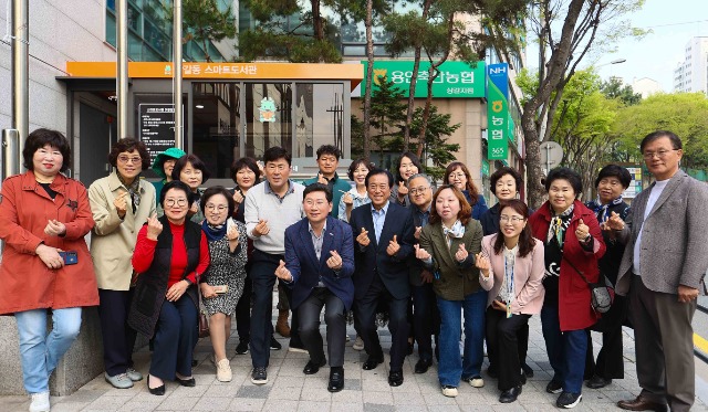 3-4. 이상일 용인특례시장이 지난 11일 기흥구 상갈동 행정복지센터 1층 야외 부스에서 열린 스마트도서관 11호점 개관식에서 참석자들과 기념촬영을 하고 있다..jpg