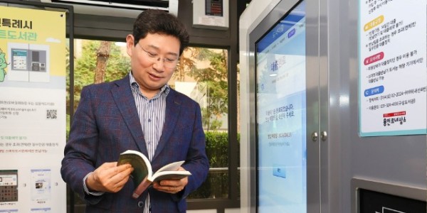 3-1. 이상일 용인특례시장이 지난 11일 기흥구 상갈동 행정복지센터 1층 야외 부스에서 열린 스마트도서관 11호점 개관식에서 도서 대출을 해보고 있다..jpg
