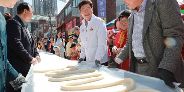 1-2. 이상일 용인특례시장(오른쪽에서 두번째)이 13일 용인중앙시장 왁자지껄 봄 축제 가래떡 뽑기 행사에 참여하고 있다..JPG