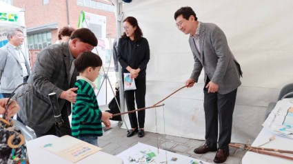 9-2. 이상일 용인특례시장이 환경교육박람회에 참가한 한 어린이와 체험부스에서 멸종위기동물을 구하는 체험 활동을 하고 있는 모습..JPG