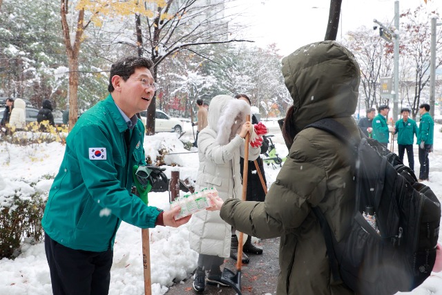 9-1. 이상일 용인특례시장이 28일 오전 용인경전철 동백역부터 동백2동주민센터 주변까지 제설작업을 펼쳤다. 제설작업 중인 이 시장을 본 한 대학생이 이상일 시장에게 요구르트를 전달하며 고마움을 표했다..JPG