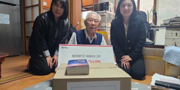 7. 16일 김상운 작가의 자택에서 김 작가가 시 도서관 관계자에게 도서를 기증하고 있다.jpg