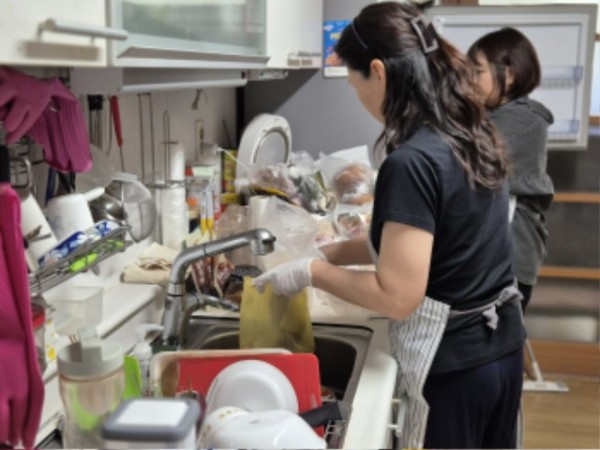 1-1. 주방정리 매니저가 홀몸 어르신 가정을 방문해 냉장고와 주방을 정리하고 있다.jpg