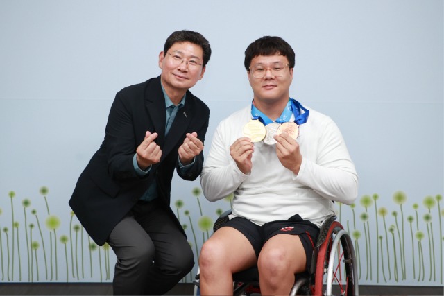 11-1. 이상일 용인특례시장(왼쪽)은 1일 시장실에서 열린 용인시 직장운동경기부 장애인수영팀 우승 메달 봉납식에서 조기성 선수(오른쪽)에게 메달을 수여했다.jpg