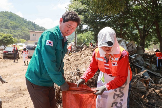 1-1. 이상일 용인특례시장이 25일 가평군의 수해복구 현장에서 용인시자원봉사센터의 레디용 봉사단과 함께 피해복구 작업을 진행 중이다..JPG
