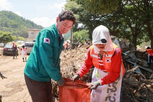 1-1. 이상일 용인특례시장이 25일 가평군의 수해복구 현장에서 용인시자원봉사센터의 레디용 봉사단과 함께 피해복구 작업을 진행 중이다..JPG